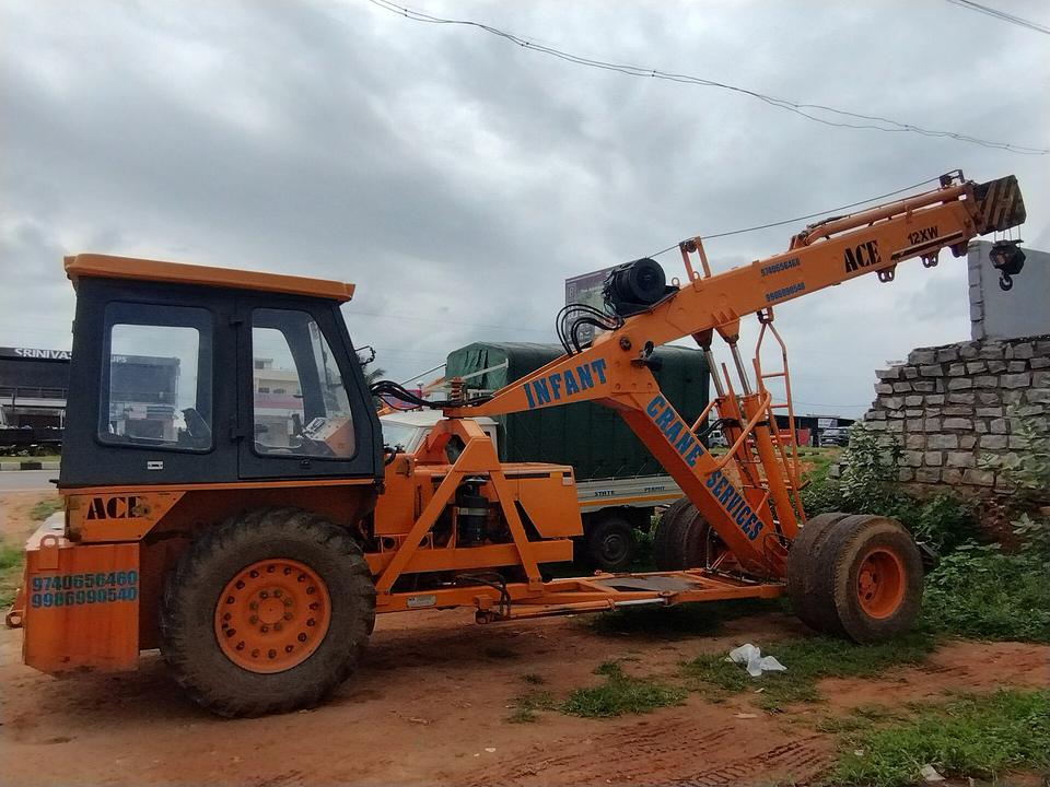 Orange ACE pick-and-carry crane parked on open ground in Bangalore