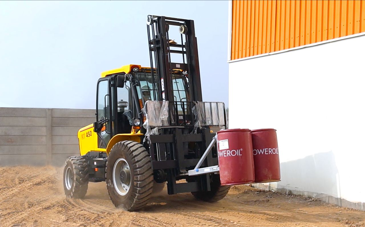 CMPL All Rounder RT450 lifting oil drums on its forks on a dusty site